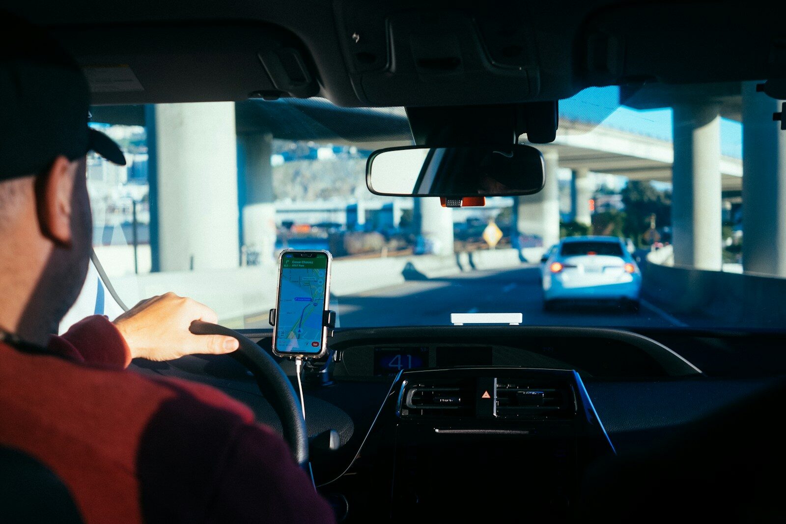 Driver using smartphone navigation while driving on highway